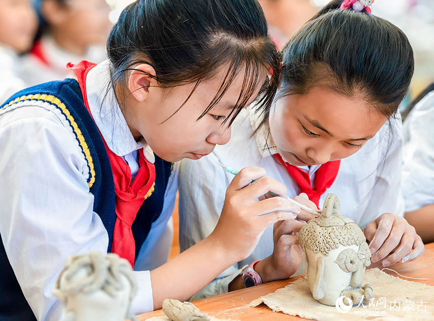 呼和浩特市玉泉区西菜园小学陶艺社团学生在制作陶艺作品。丁根厚摄