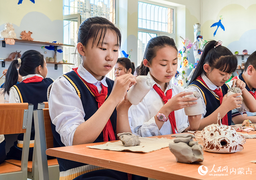 呼和浩特市玉泉区西菜园小学陶艺社团学生在制作陶艺作品《奇特的脸》。丁根厚摄