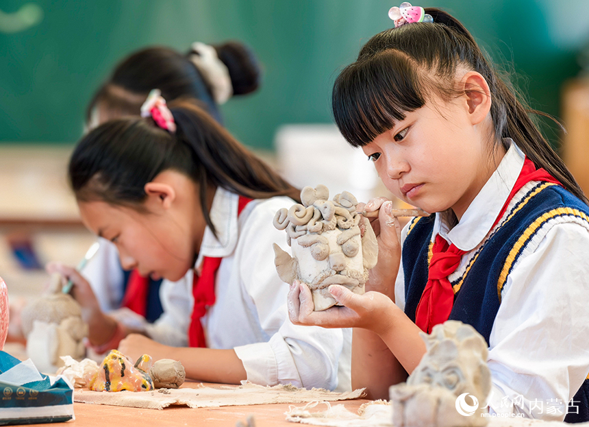 呼和浩特市玉泉区西菜园小学陶艺社团学生在制作陶艺作品。丁根厚摄