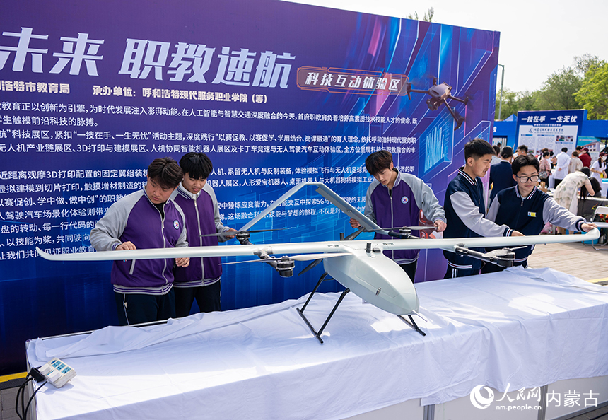 学生们在呼和浩特现代服务职业学院展示区了解无人机行业应用的相关知识。丁根厚摄