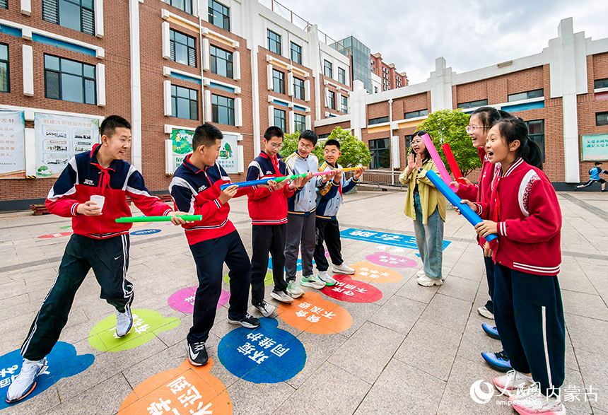 呼和浩特市玉泉區恆昌店巷小學五裡營校區心理游園會活動現場，學生正在參加“同心協力-行珠萬裡”趣味游戲。丁根厚攝