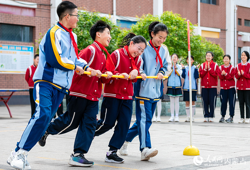 呼和浩特市玉泉區恆昌店巷小學五裡營校區心理游園會活動現場，學生正在參加“推杆跑”趣味游戲。丁根厚攝
