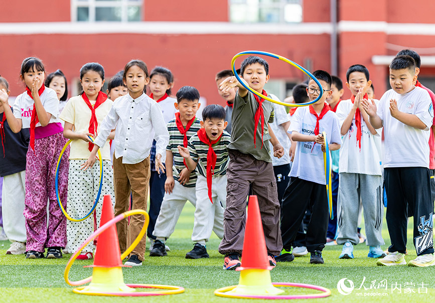 5月26日，內蒙古呼和浩特市玉泉區小召小學體育社團的學生在玩套圈游戲。丁根厚攝