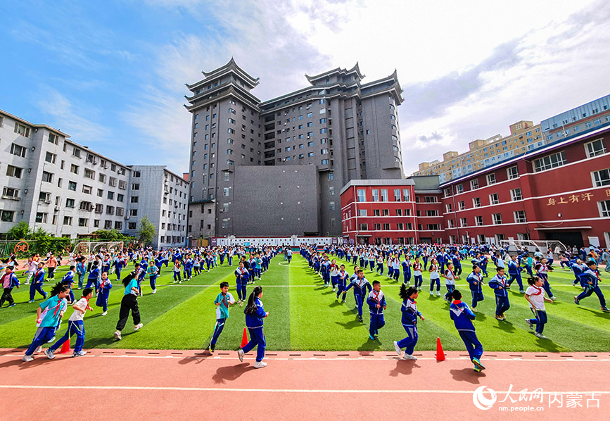 5月26日，內蒙古呼和浩特市玉泉區小召小學的學生在大課間進行集體環形慢跑。丁根厚攝