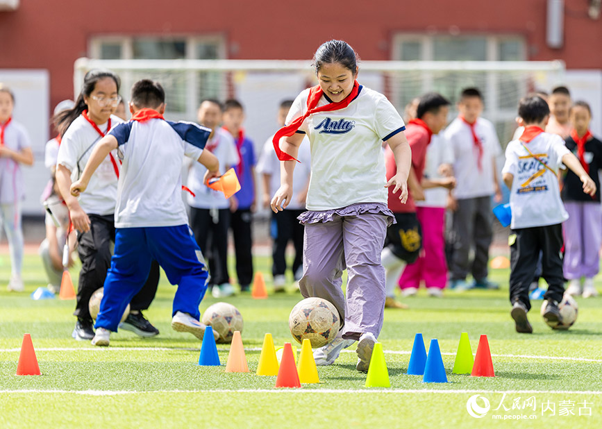 5月26日，內蒙古呼和浩特市玉泉區小召小學體育社團的學生在玩足球趣味游戲。丁根厚攝