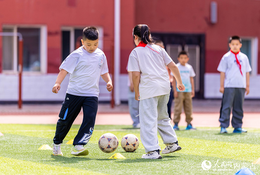 5月26日，內蒙古呼和浩特市玉泉區小召小學的學生在課間進行足球趣味游戲。丁根厚攝