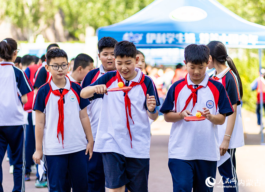 5月29日，內蒙古呼和浩特市玉泉區石東路小學學生在操場上參加“顛球跑”趣味游戲，歡慶“六一”國際兒童節。丁根厚攝