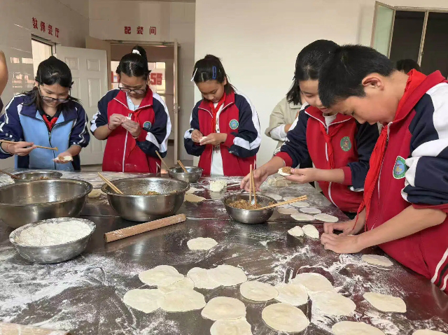 六年级的学生们热情满满，齐心协力动手包饺。高力板小学供图