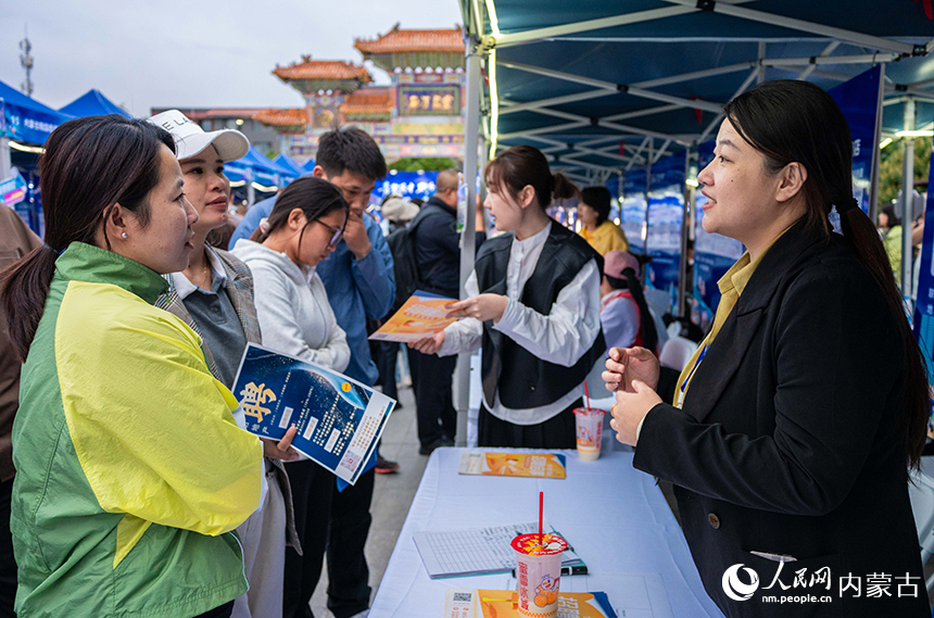 呼和浩特市高校畢業生系列巡回招聘活動現場，求職者與招聘人員在洽談。丁根厚攝