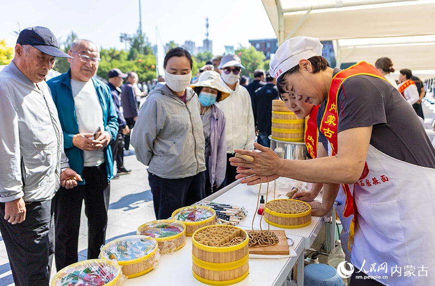 内蒙古自治区级非遗传承人在“文化和自然遗产日”活动现场展示莜面饮食制作技艺。丁根厚摄