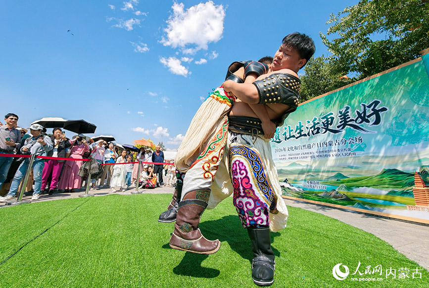 6月13日，游客在“文化和自然遗产日”活动现场观看搏克比赛。丁根厚摄