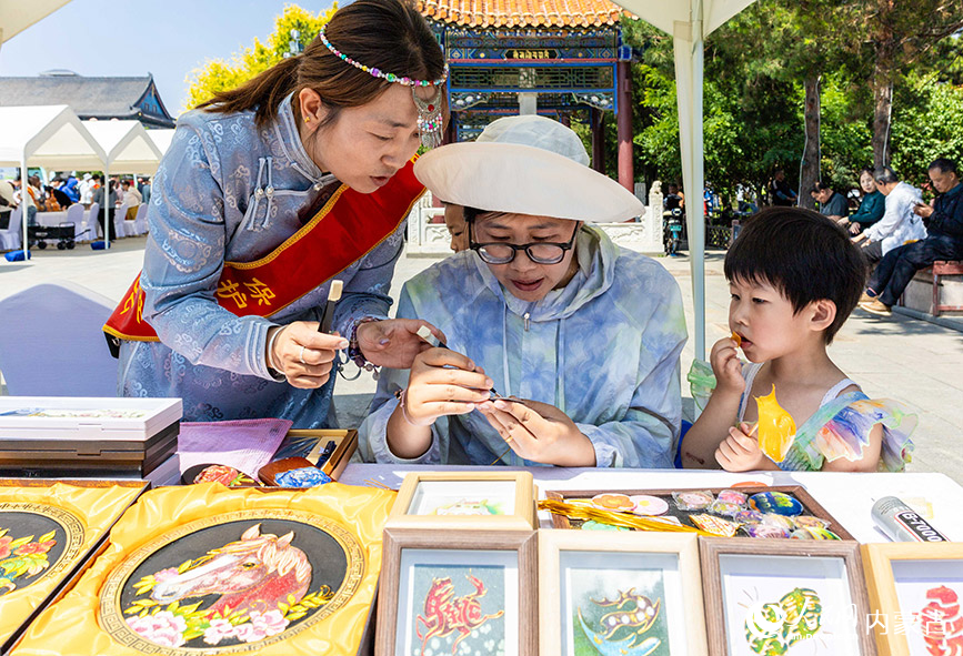 6月13日，游客在“文化和自然遗产日”活动现场体验掐丝珐琅的制作技艺。丁根厚摄