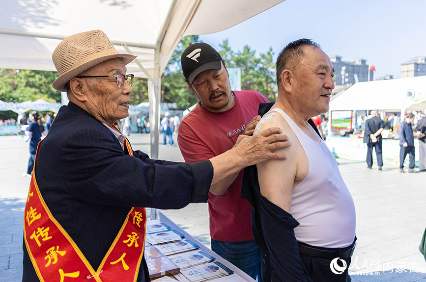 6月13日，游客在“文化和自然遗产日”活动现场体验膏贴疗法。丁根厚摄
