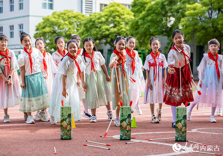 呼和浩特市玉泉区五塔寺东街小学“我们的节日·端午”主题活动现场，学生们参加端午投壶游戏。丁根厚摄
