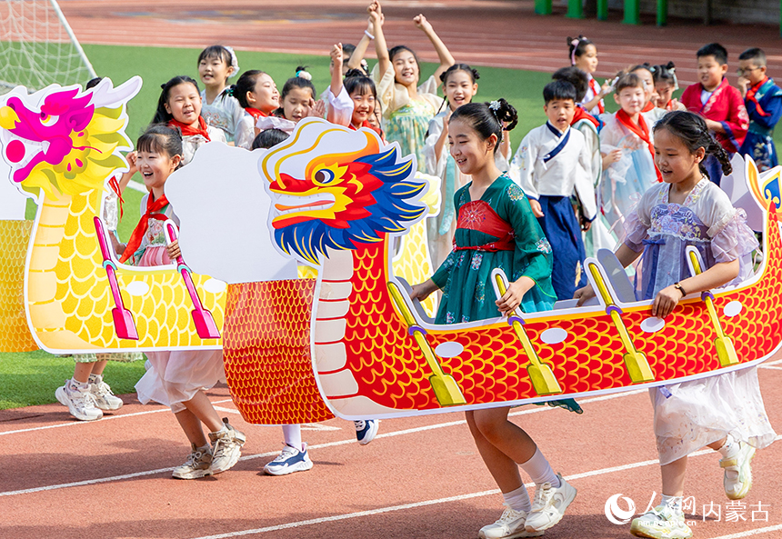 呼和浩特市玉泉区五塔寺东街小学“我们的节日·端午”主题活动现场，学生进行旱地龙舟比赛。丁根厚摄