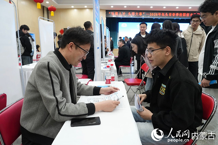 郝振宇（左）代表企业参加包头市在东北大学举办的专场招聘活动。包头市融媒体中心 许家轩摄