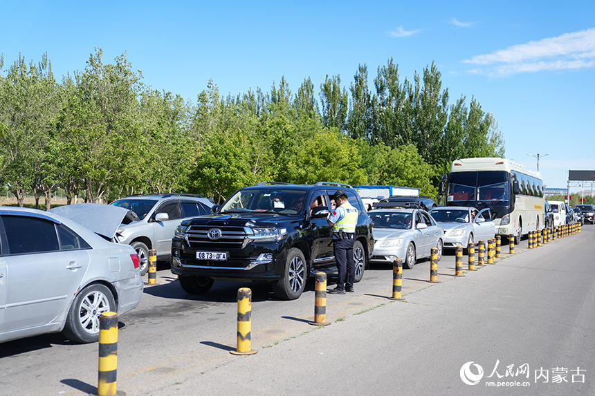 二连出入境边防检查站移民管理警察为旅客提供通关咨询。杨金烨摄
