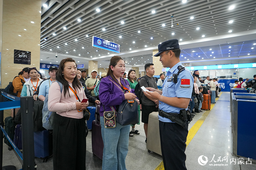 二连出入境边防检查站移民管理警察为旅客提供通关咨询。杨金烨摄