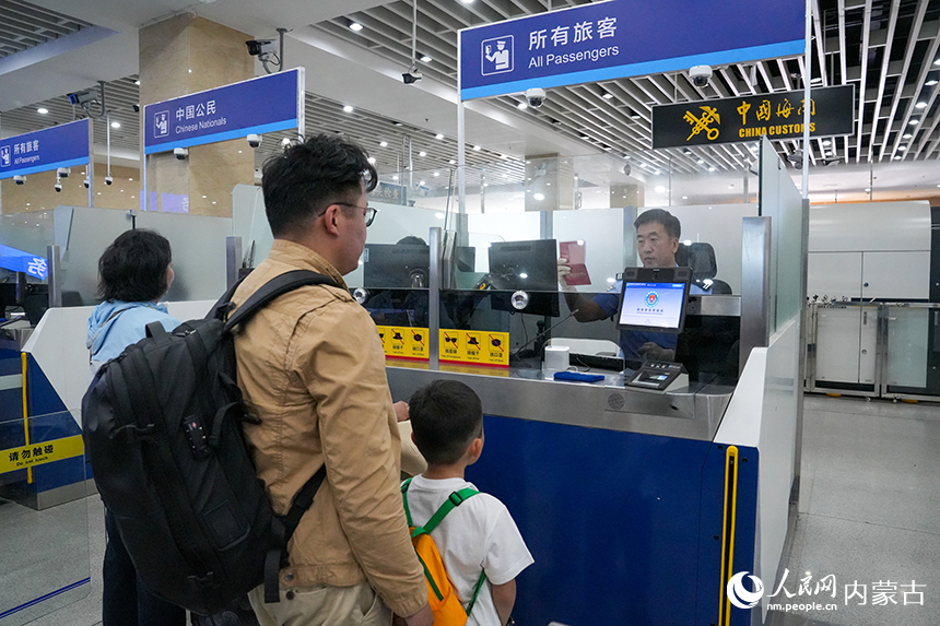 二连出入境边防检查站移民管理警察有序为旅客办理通关手续。杨金烨摄