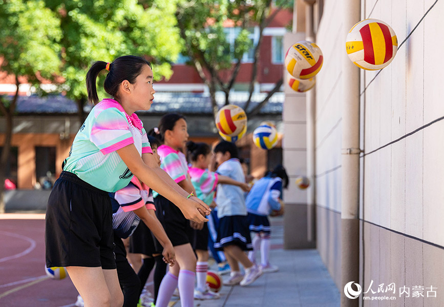 6月24日，内蒙古呼和浩特市玉泉区南茶坊小学，学生们在排球训练中练习垫球动作。丁根厚摄