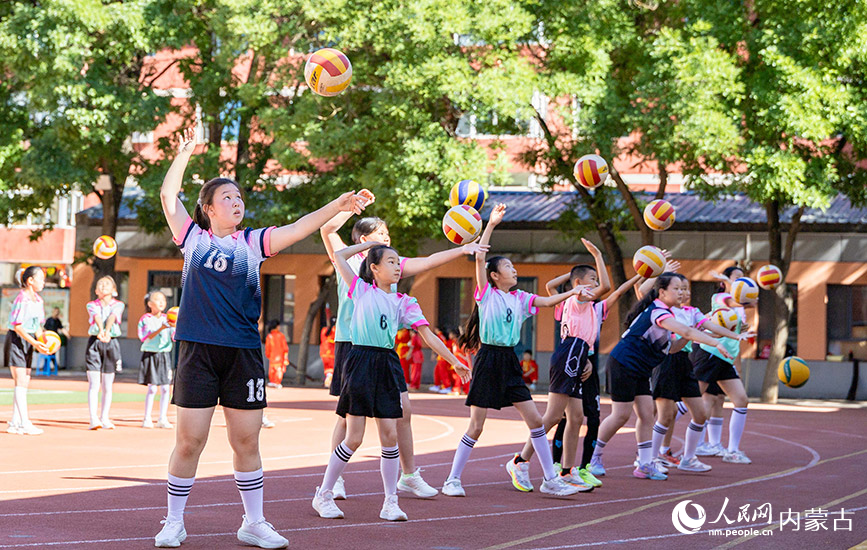 6月24日，内蒙古呼和浩特市玉泉区南茶坊小学，学生们在排球训练中练习扣球动作。丁根厚摄