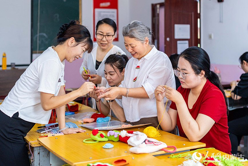 7月9日，在呼和浩特市玉泉區內蒙古揚帆職業培訓學校，學員們在老師（右二）指導下學習手工編織技藝。丁根厚攝
