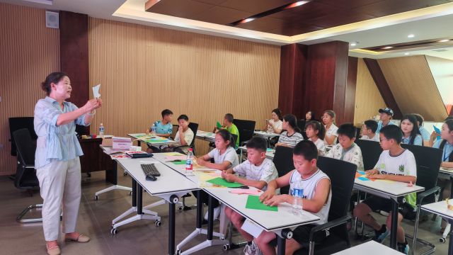 美术老师教孩子们剪纸。