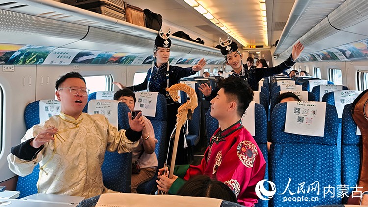 兴和县乌兰牧骑演员在列车上为乘客表演。人民网记者 张雪冬摄