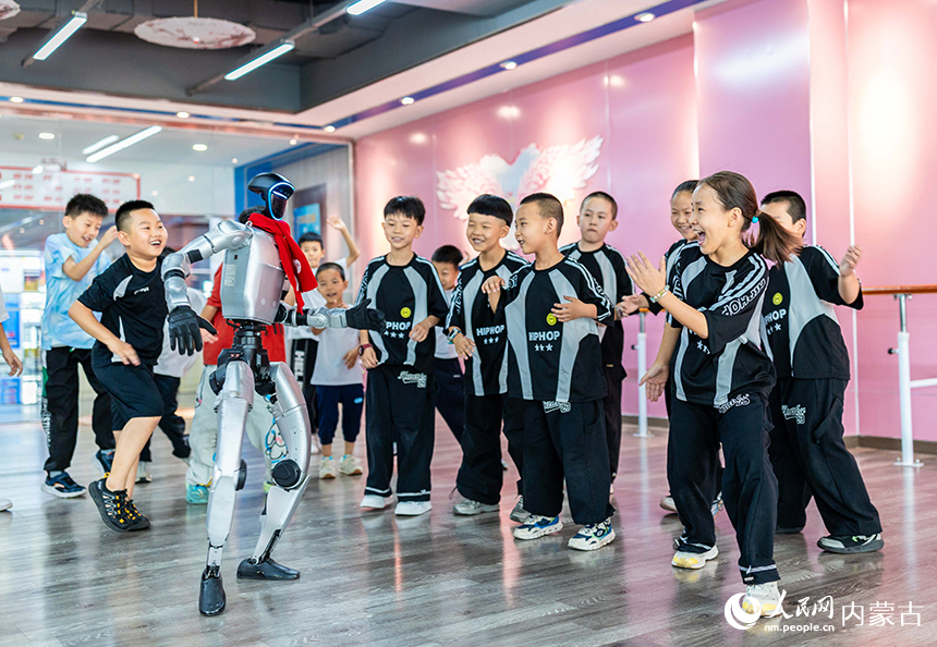 孩子們在內蒙古呼和浩特市玉泉區青少年宮與人形機器人一起排練街舞。丁根厚攝