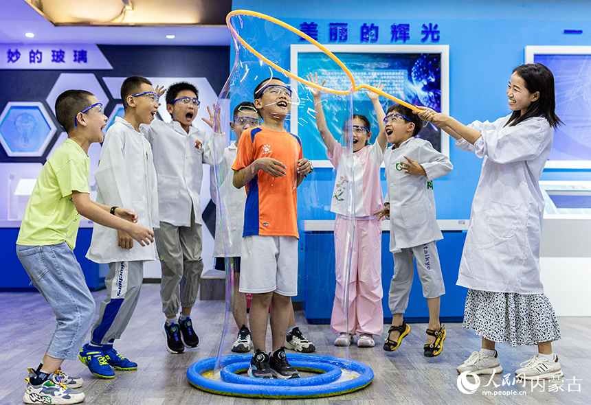 孩子们在内蒙古呼和浩特市玉泉区青少年宫体验“泡泡套人”科学秀。丁根厚摄