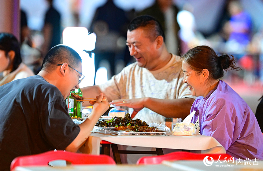 游客在鄂托克前旗2026年物资交流会上品尝美食。王正摄