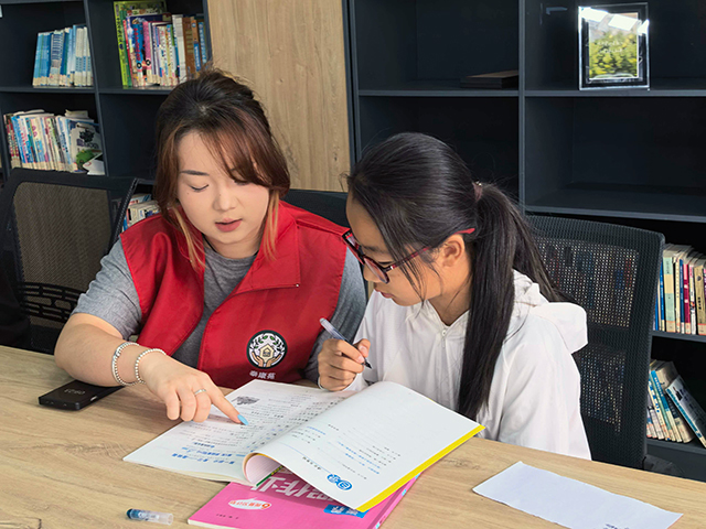 富兴街道沃热社区开展暑期公益托管，大学生志愿者老师为参学学生进行一对一课业辅导。