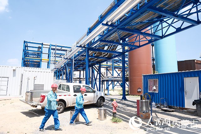 西来峰LNG工厂内，工人正在新建装置下穿行作业。人民网记者 刘艺琳摄