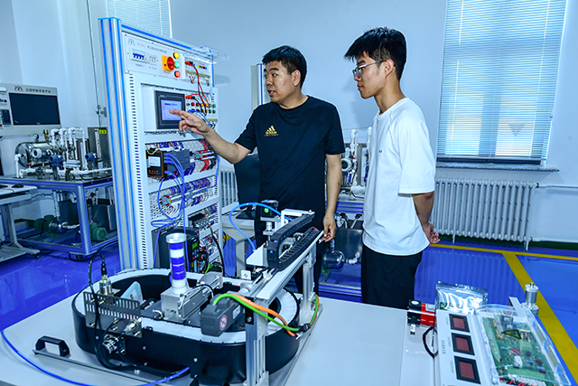 老师正在给学员讲解电力设备操作方法。张启民摄