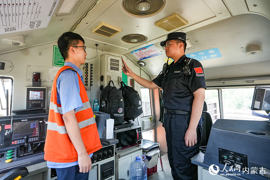 二连出入境边防检查站移民管理警察正在查验中欧班列司机证件。杨金烨摄