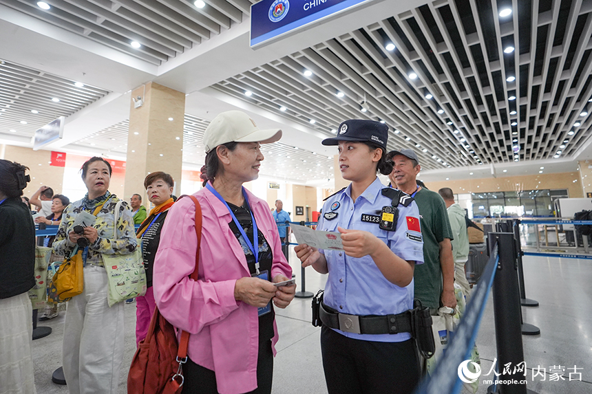 二连出入境边防检查站移民管理警察为参加边境一日游旅客提供通关咨询。杨金烨摄
