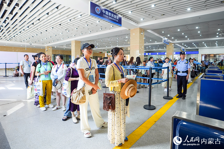 二连浩特公路口岸联检大厅内参加边境一日游的旅客有序排队办理通关手续。杨金烨摄