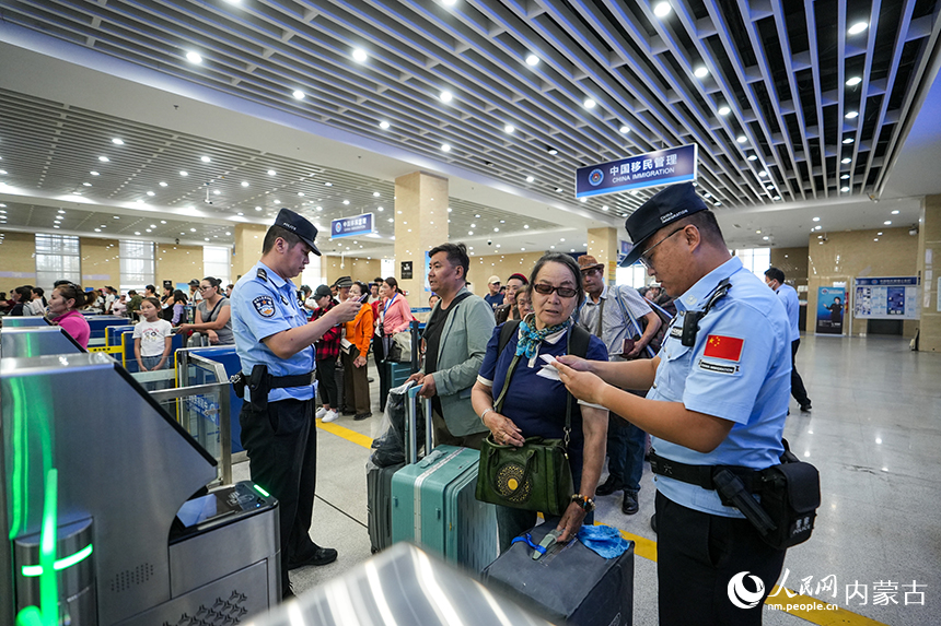 二连出入境边防检查站移民管理警察查验入境旅客证件。杨金烨摄