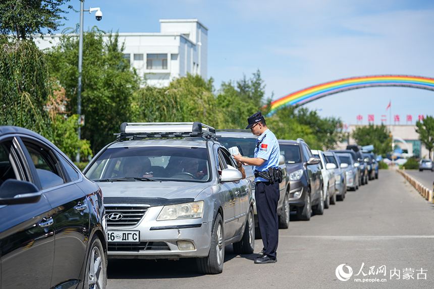 二连出入境边防检查站移民管理警察查验入境旅客证件。杨金烨摄