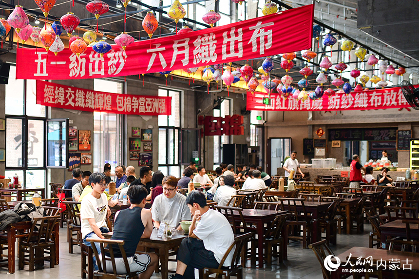 市民和游客在“包棉1958”主题文化街区里的包棉大食堂聊天休闲。王正摄