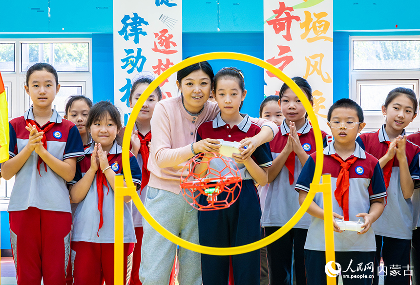 呼和浩特市新城区北垣小学新雅校区学生们体验无人机穿越障碍项目。丁根厚摄