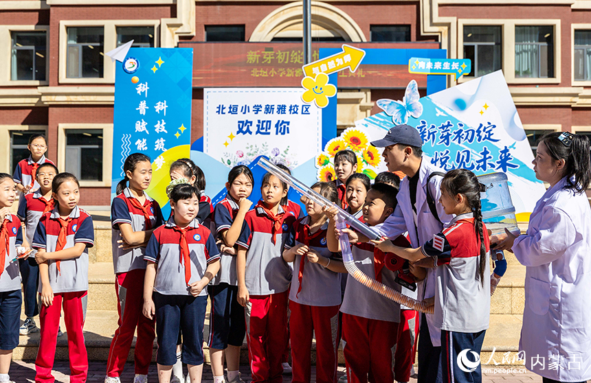 呼和浩特市新城区北垣小学新雅校区学生们体验乒乓球“空气炮”互动项目。丁根厚摄