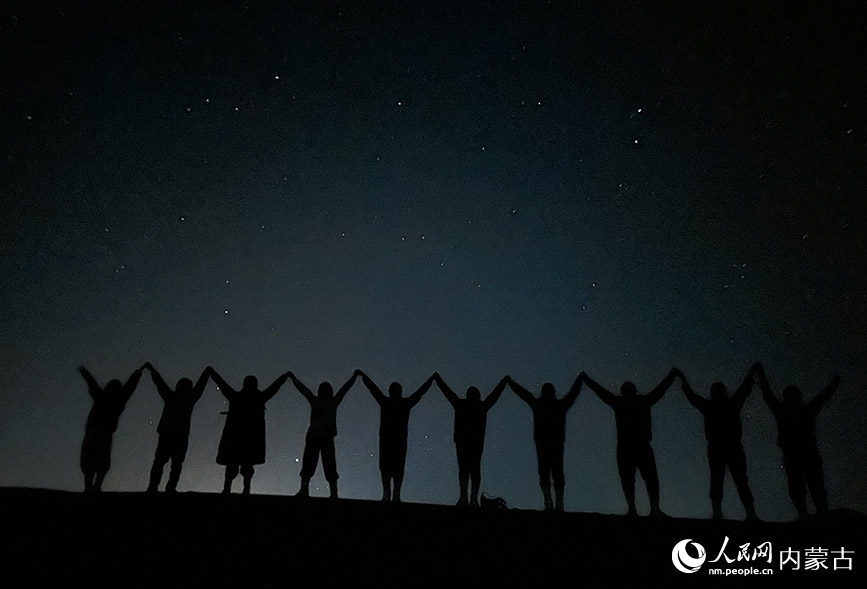 游客结伴在夜鸣沙徒步观星。人民网记者 苗阳摄