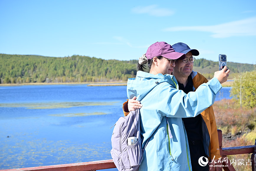 游客在杜鹃湖与美景合影。人民网记者 寇雅楠摄