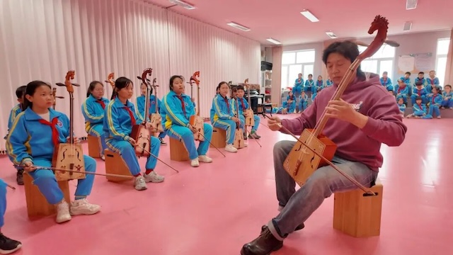 巴图老师教马头琴社团的孩子们演奏。