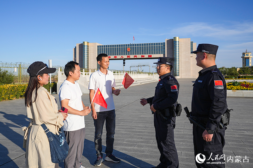 卫疆特勤队民警在国门前为游客宣讲国门安全知识。郭鹏杰摄