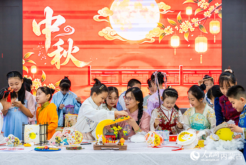 呼和浩特市玉泉区清泉街小学“品民俗-迎中秋”主题活动现场，师生们在绘制中秋手工作品。丁根厚摄