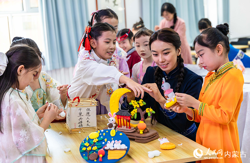 呼和浩特市玉泉区清泉街小学“品民俗 迎中秋”主题活动现场，师生们在绘制中秋主题彩泥画。丁根厚摄
