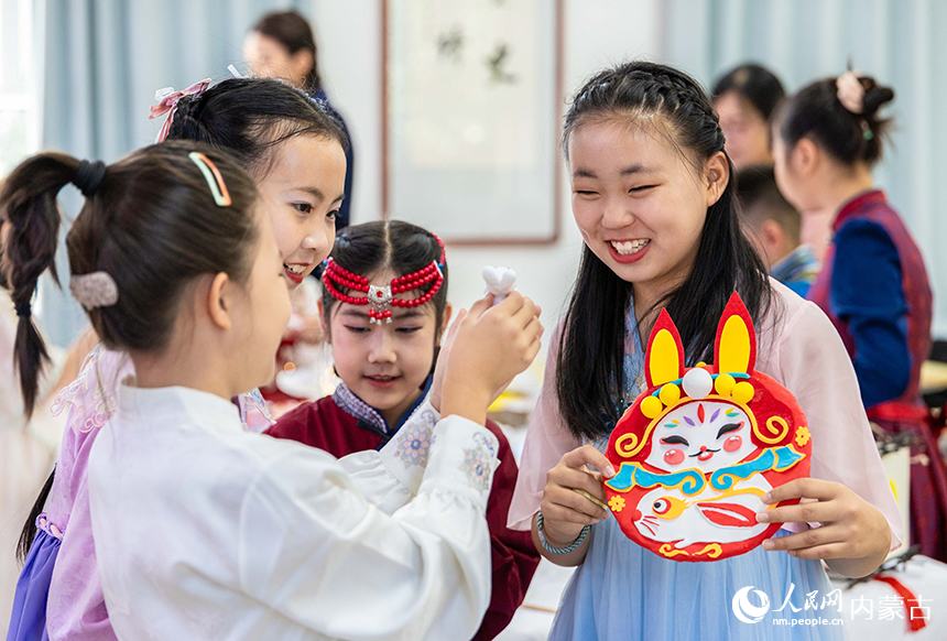 呼和浩特市玉泉区清泉街小学“品民俗 迎中秋”主题活动现场，学生们在展示绘制的兔爷儿彩泥画。丁根厚摄