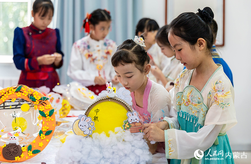 呼和浩特市玉泉区清泉街小学“品民俗 迎中秋”主题活动现场，学生们在制作玉兔花灯。丁根厚摄